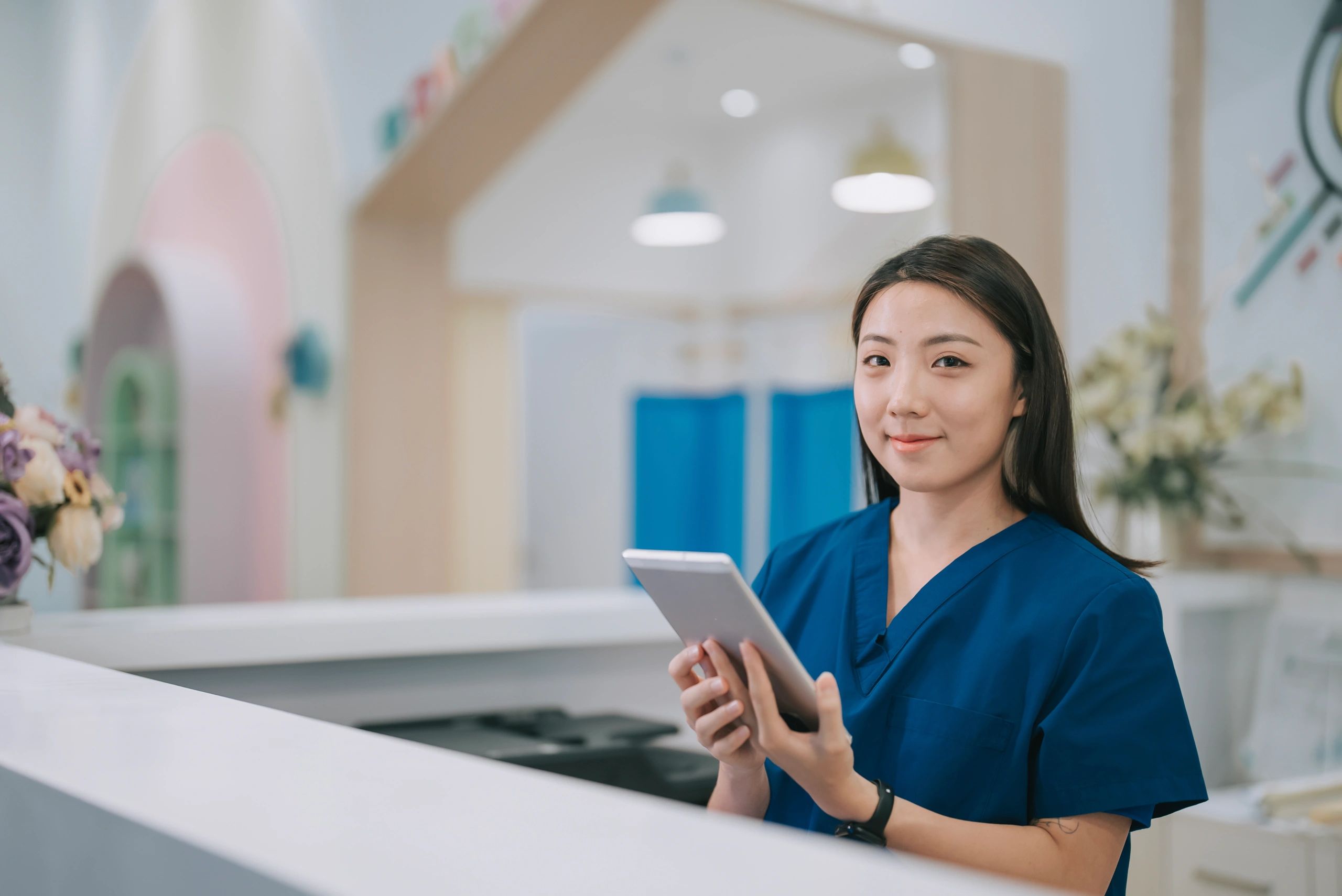 Hospital staff member at a reception counter representing service coordination