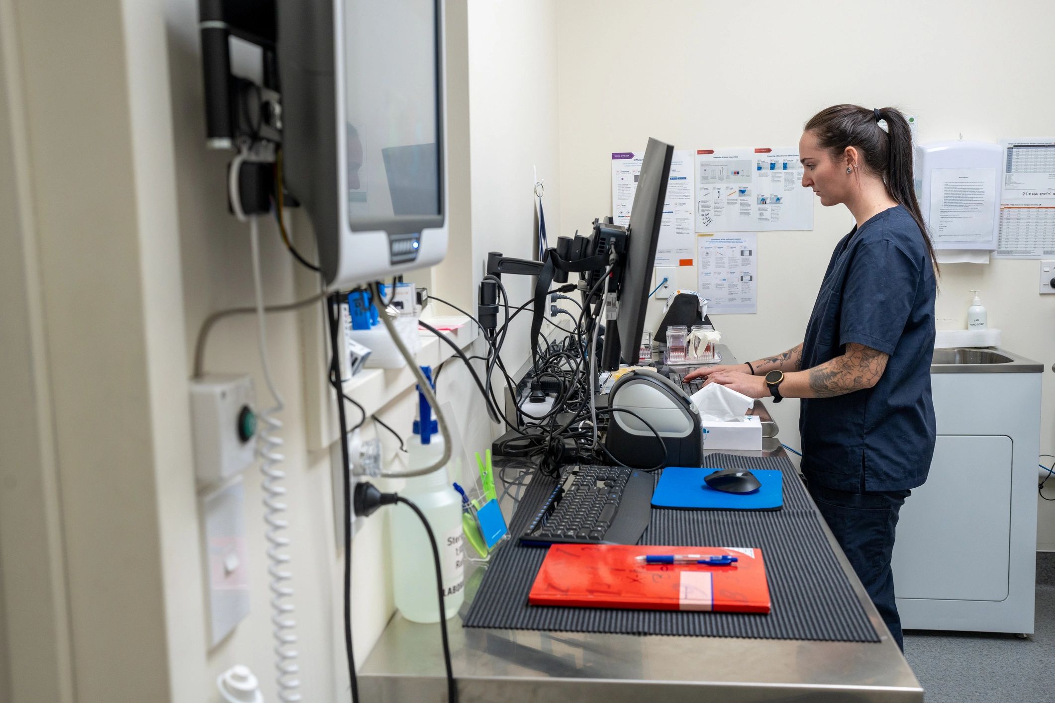 Biomedical professional reviewing service information on a computer in a clinical lab